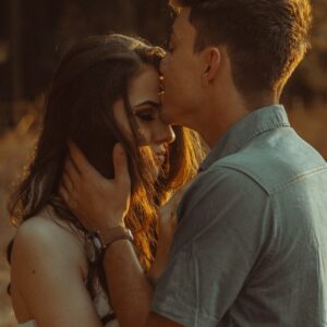 man kissing woman forehead