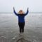 Woman Standing on the Beach Raising Her Hands