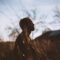 Silhouette of Man Sitting on Grass Field at Daytime