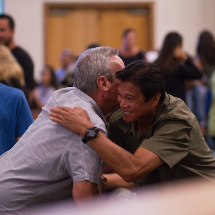 two men hugging on focus photography