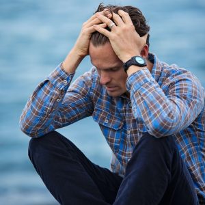 Man in Blue and Brown Plaid Dress Shirt Touching His Hair