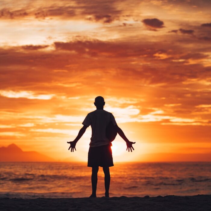 silhouette of man running on beach during sunset