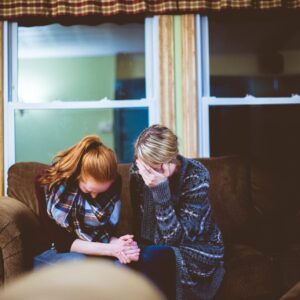 man and woman sitting on sofa in a room