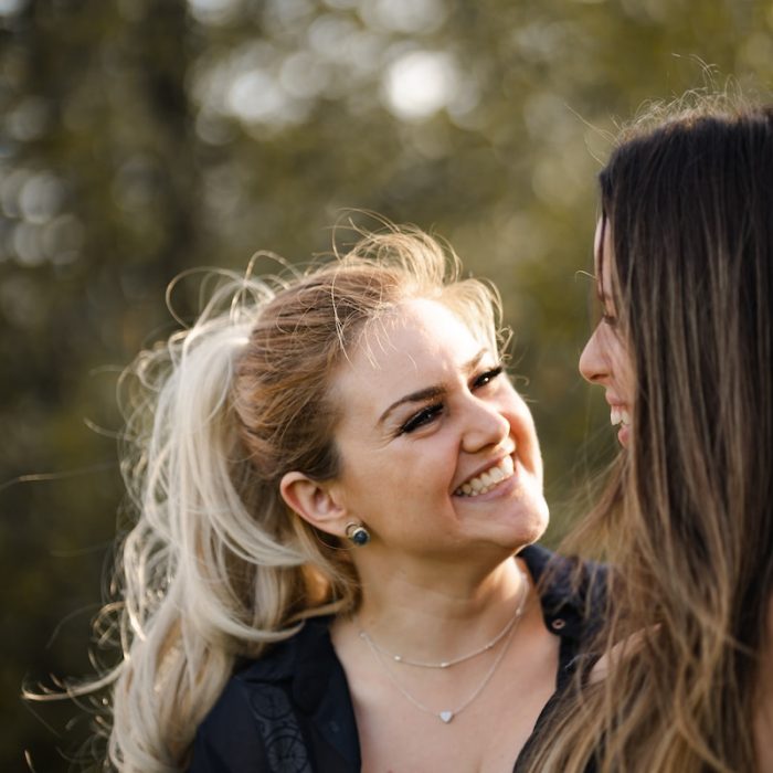 woman in black shirt smiling beside woman in black shirt