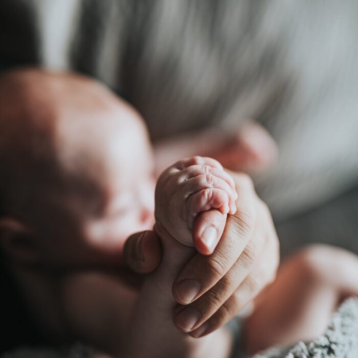 person holding babys feet