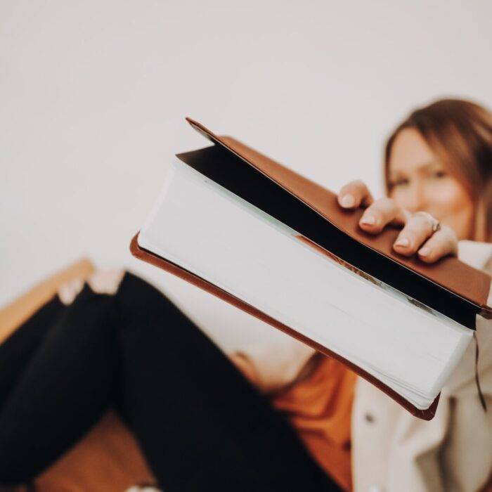 woman in black pants reading book