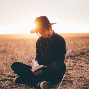 person in black sweater opening book