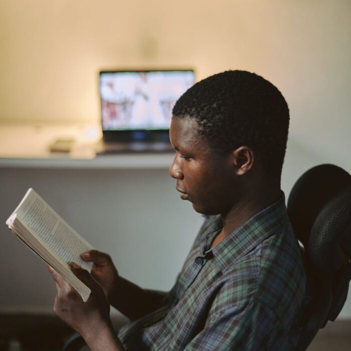 man in blue and white plaid button up shirt reading book