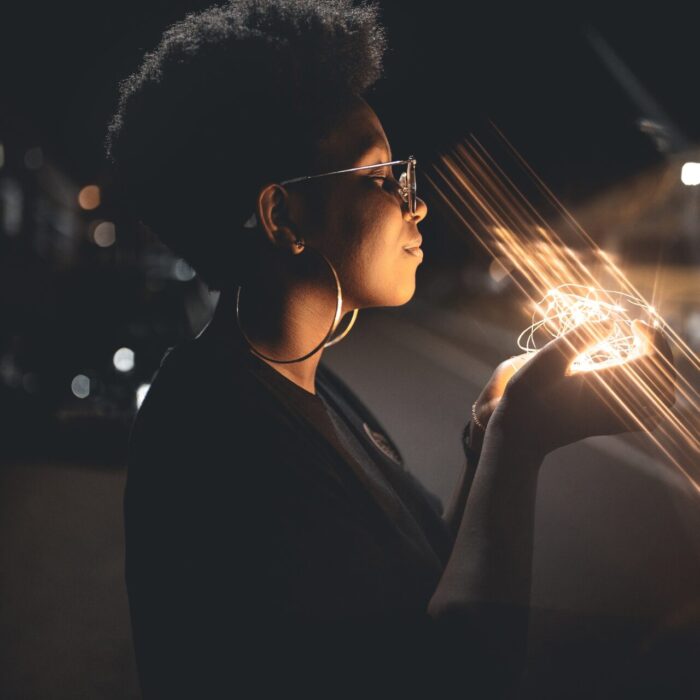 woman standing and holding string lights