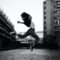 woman jumps on grayscale photography