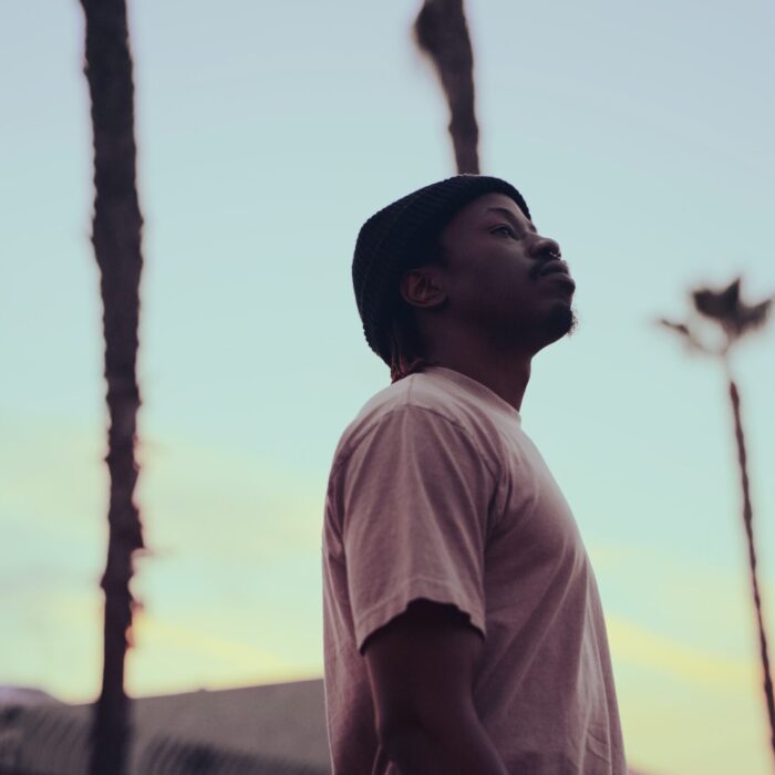 a man standing in front of palm trees