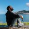 man sitting on a concrete bench overlooking the beach