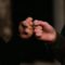 person holding gold ring in dark room